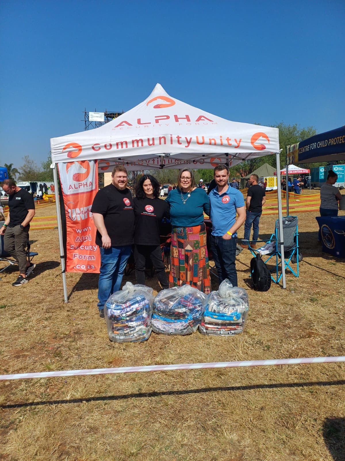 MAP volunteers at the Alpha Security Forum community stand with bagged donations