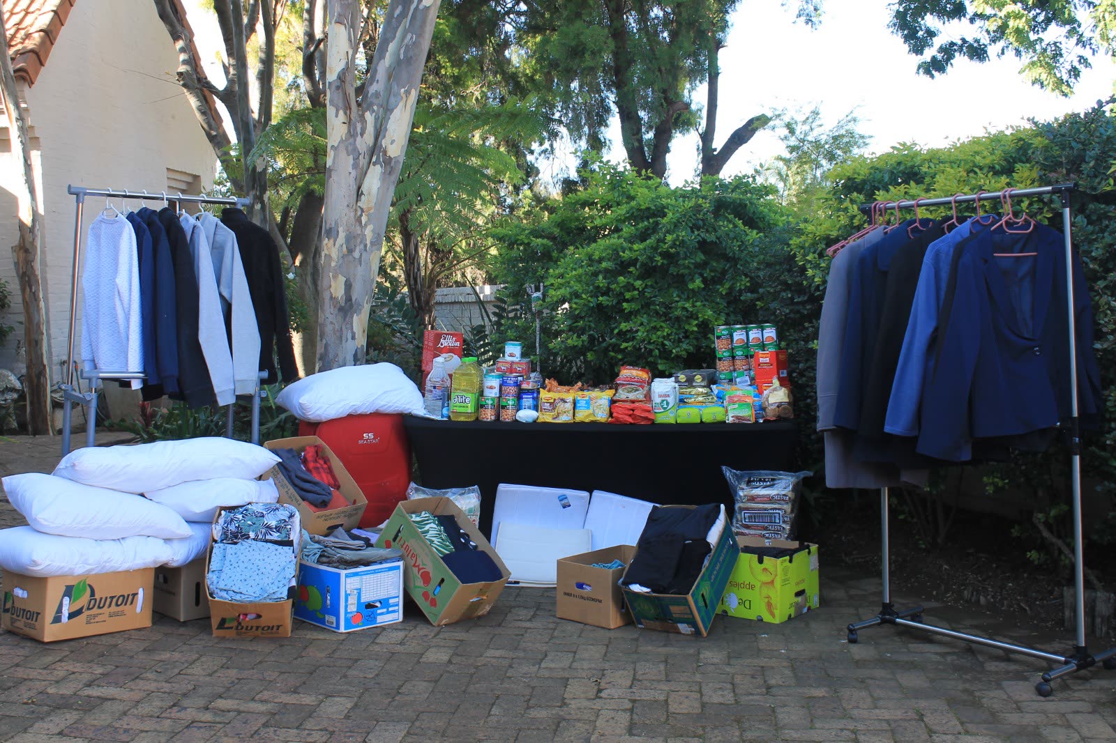 Donated food, bedding and clothing sorted on rails and in boxes before distribution