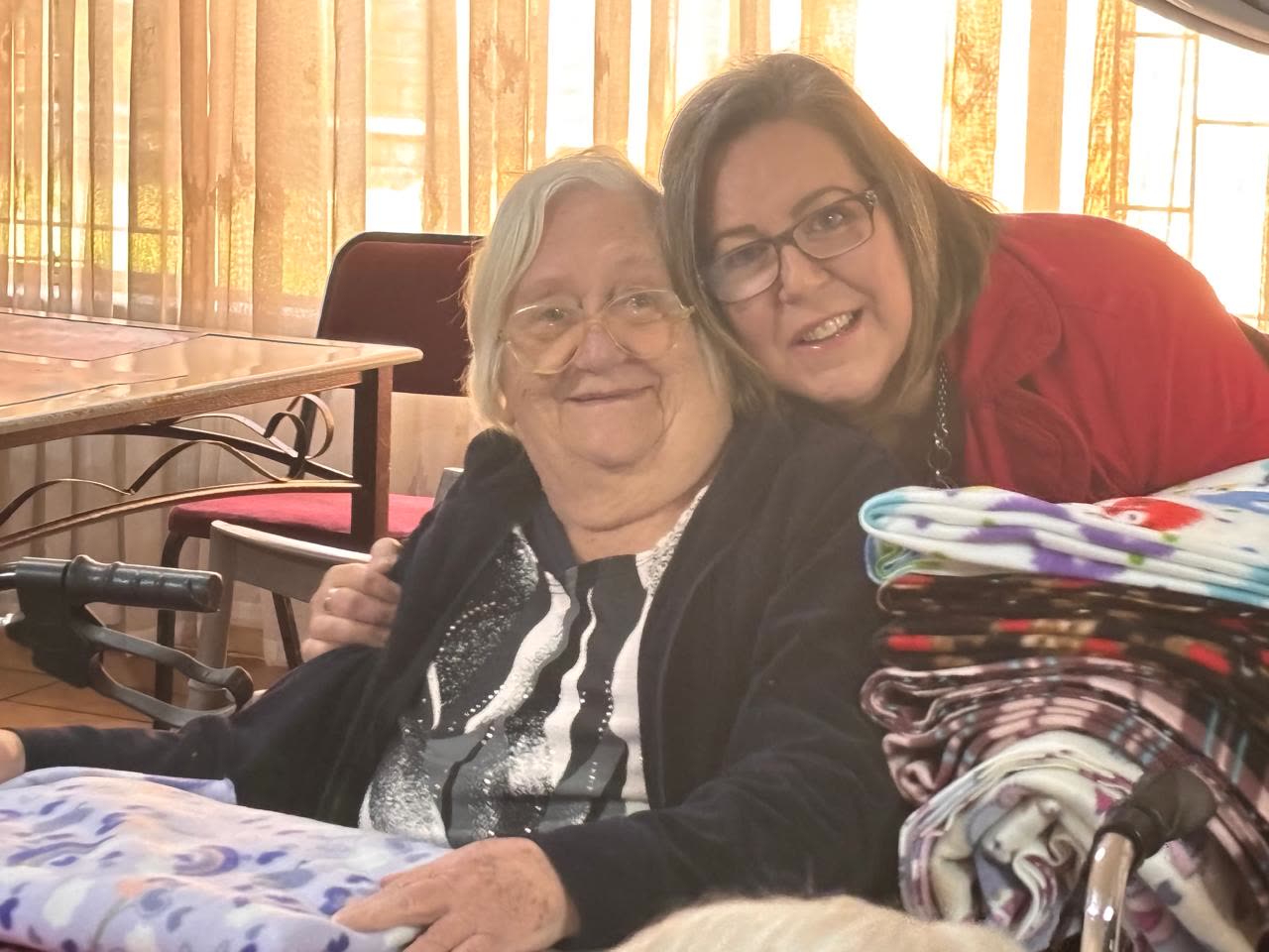 A MAP volunteer with a resident of Avondrus Frail Care Centre holding a donated fleece blanket